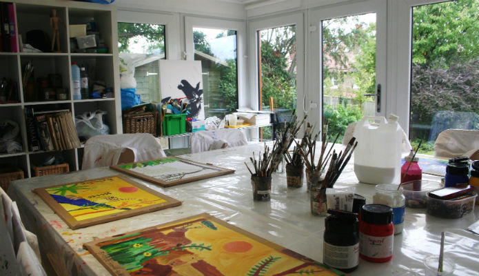 A large paint table with a garden room used for teaching young children